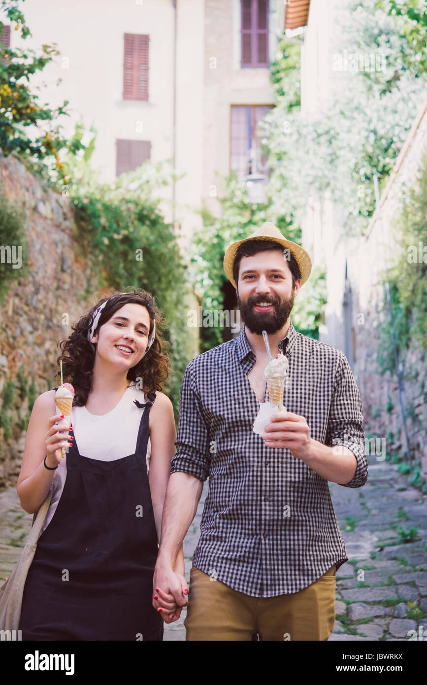 Portrait de couple avec ice cream cones sur rue pavée, Arezzo, Toscane, Italie Banque D'Images