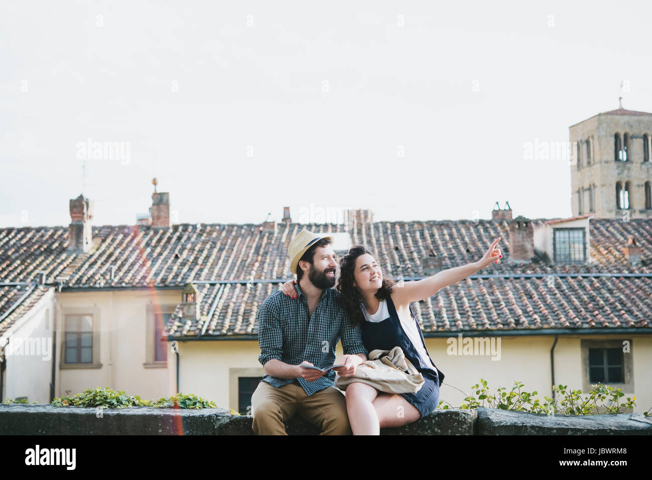 Couple sitting on wall, Arezzo, Toscane, Italie Banque D'Images