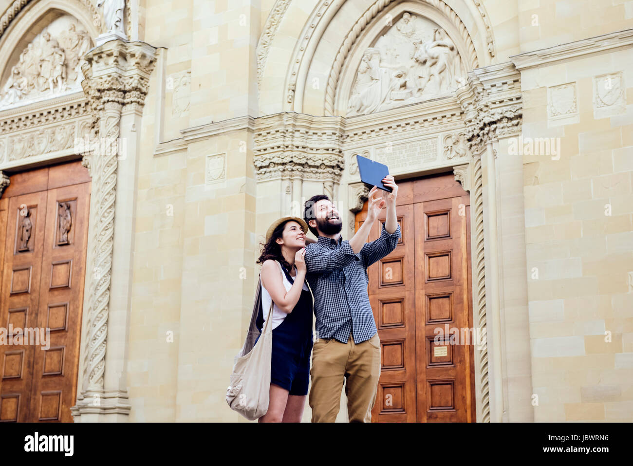 Couple taking digital tablet par selfies la cathédrale d'Arezzo, Arezzo, Toscane, Italie Banque D'Images