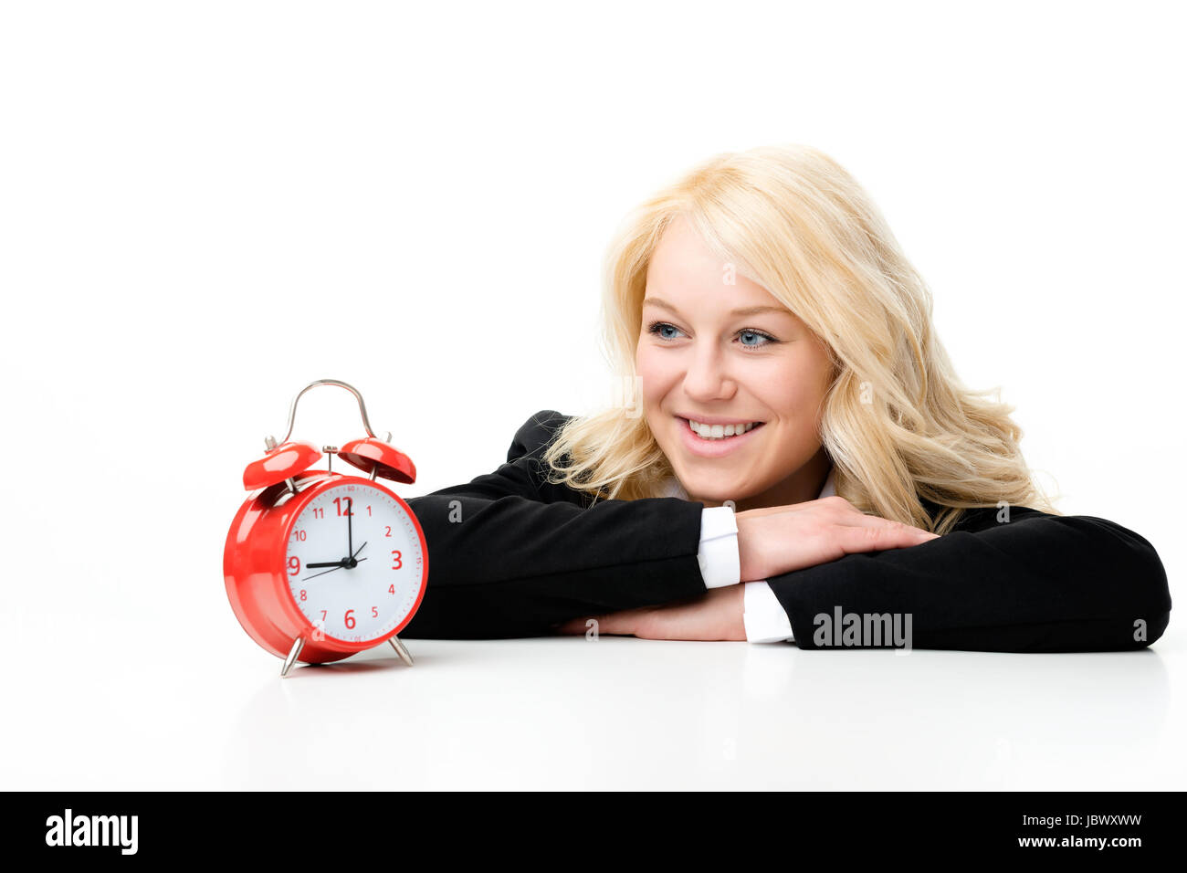 Femme blonde rire avec réveil rouge Banque D'Images