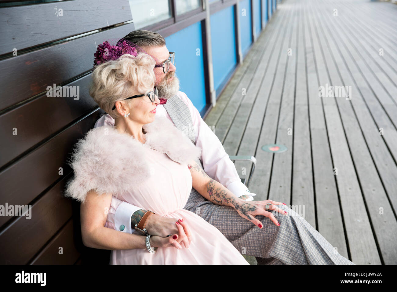 Style années 50 vintage couple sitting on pier banc Banque D'Images