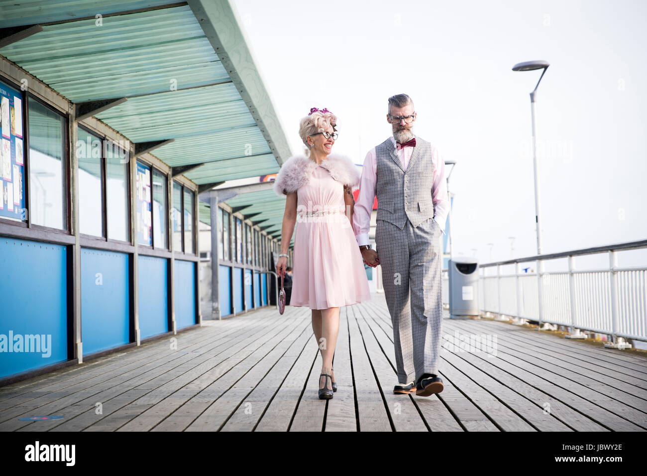 Style années 50 vintage couple strolling and holding hands on pier Banque D'Images