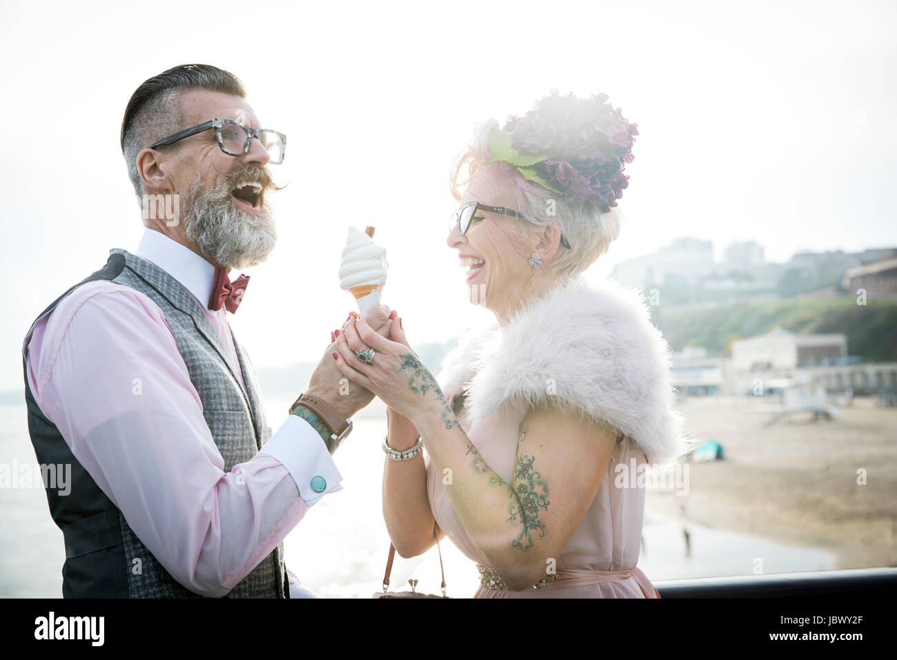 Style années 50 vintage couple avec ice cream cone, laughing on pier Banque D'Images