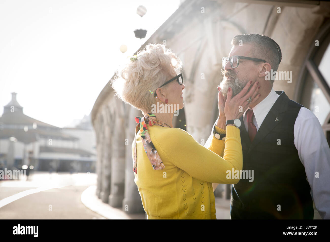 Style années 50 vintage woman cupping boyfriend's chin at coast Banque D'Images