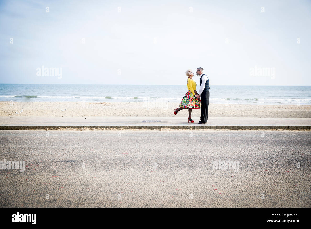 Style années 50 vintage couple holding hands on beach Banque D'Images