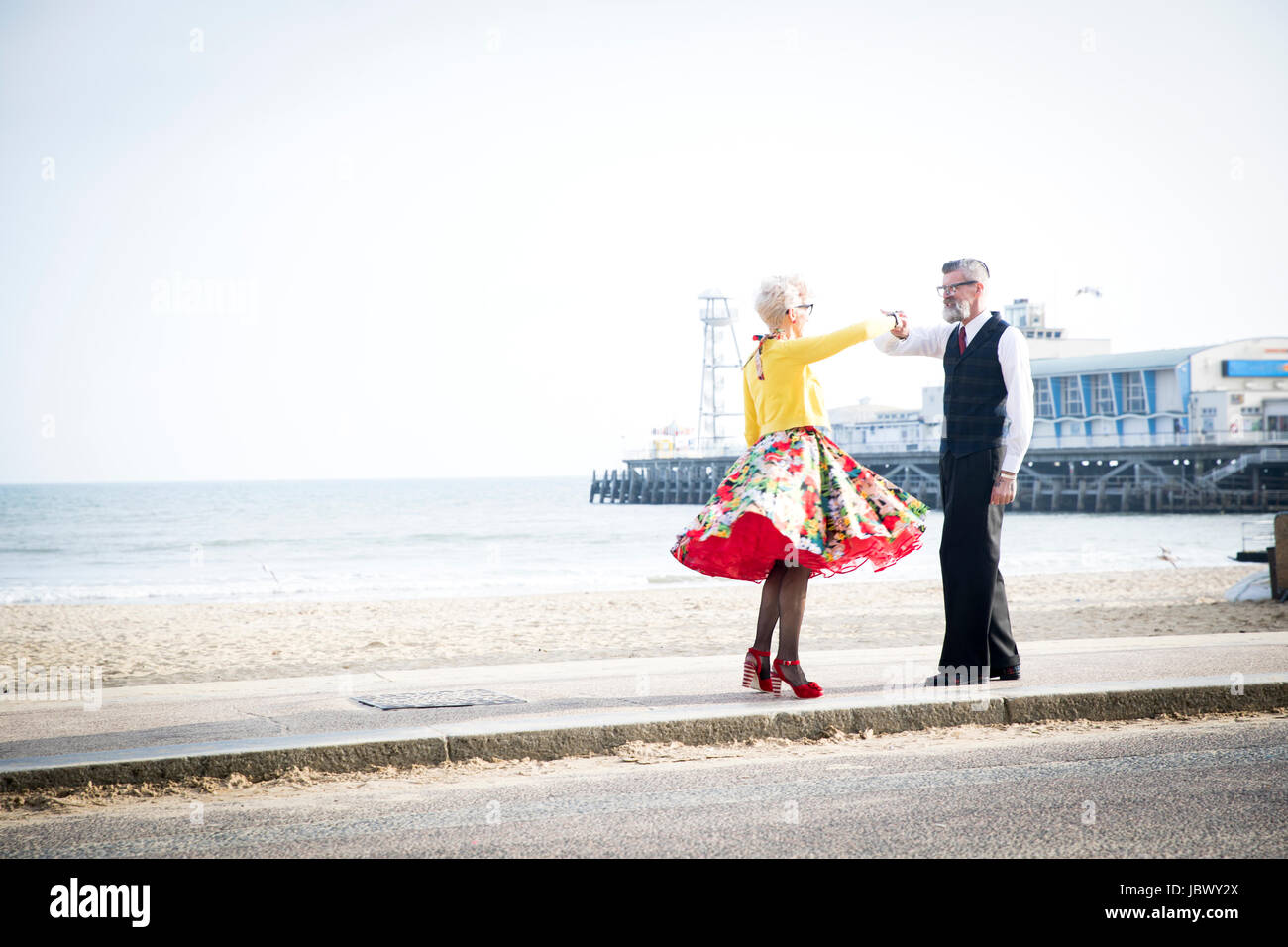 Style vintage des années 1950 et la danse couple holding hands on beach Banque D'Images