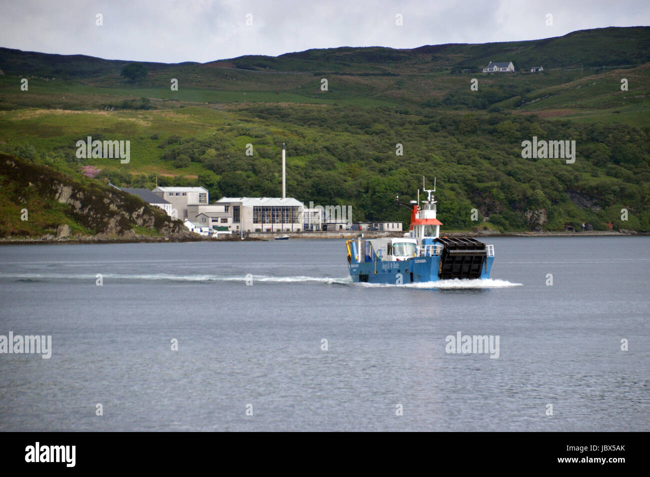 Le Jura à Islay (ferry) Dhiura Eilean arrivant à Feolin avec la distillerie de whisky Caol Ila en arrière-plan. Isle of Jura, îles écossaises. Banque D'Images