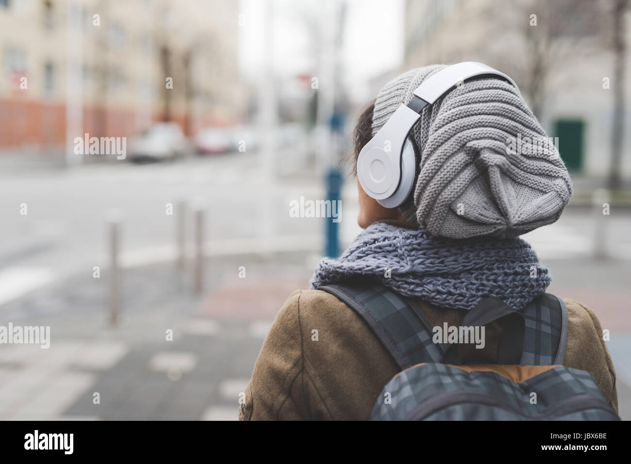 Vue arrière de la backpacker listening to headphones en ville vide Banque D'Images