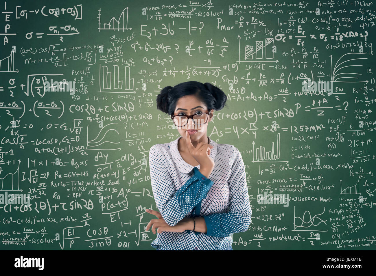 Portrait of businesswoman in front of chalkboard with formule mathématique Banque D'Images
