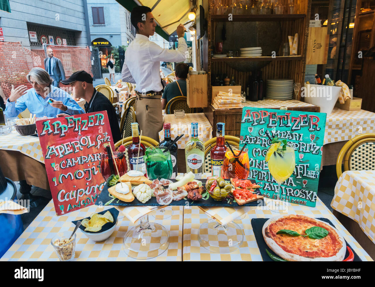 Une table pleine de nourriture et de boissons liés à la tradition milanaise de la 'aperitivo' le soir Banque D'Images
