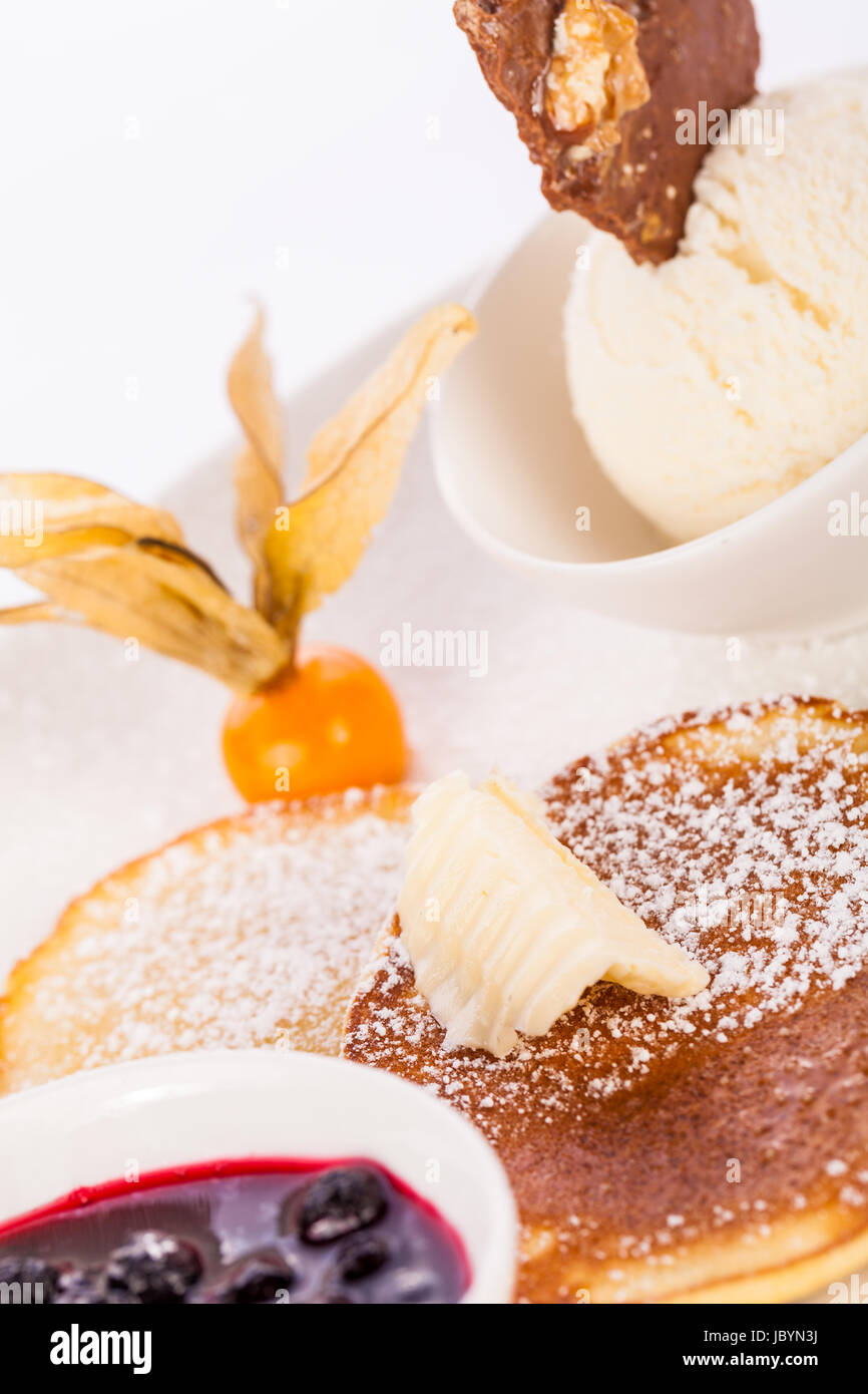 Leckere süße Pfannkuchen als Desser mit Vanilleeis angerichtet weißer bär Teller isoliert auf einem Hintergrund weißem vor Banque D'Images