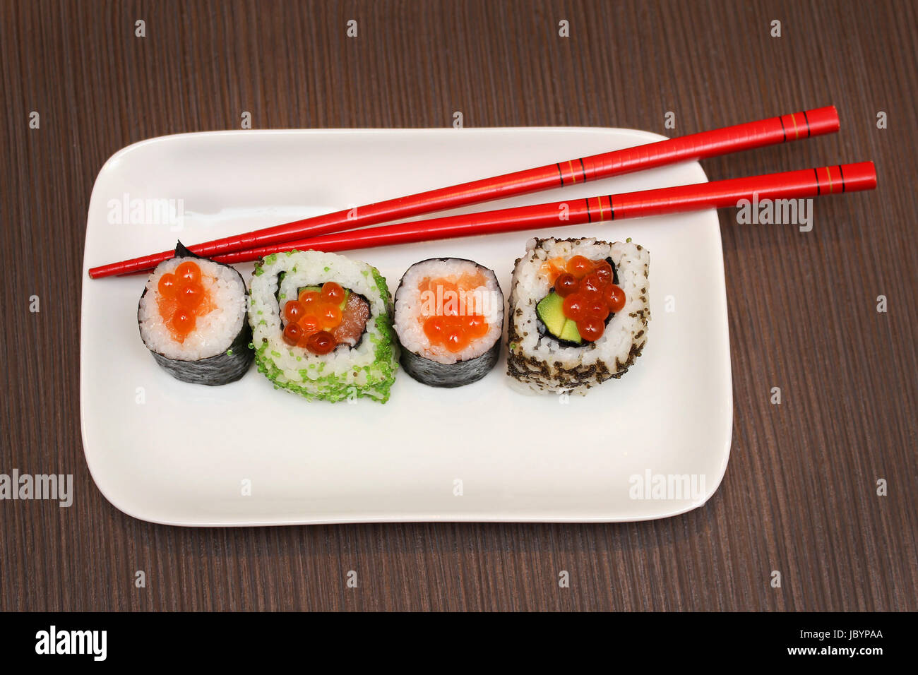 Caviar rouleaux de sushi sur plaque blanche avec baguettes rouge Banque D'Images