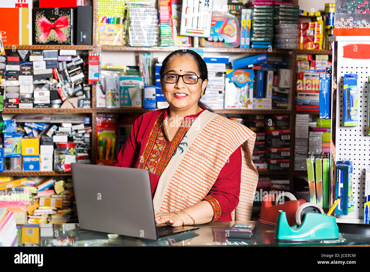 1 Indian shop keeper woman using laptop in stationary shop Banque D'Images