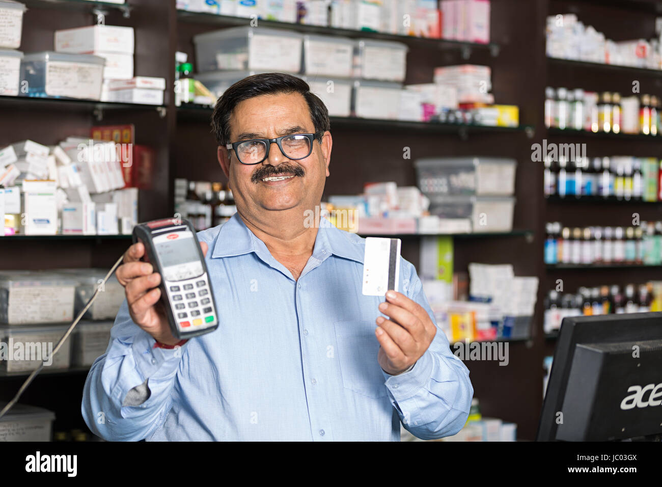 1 commerçant indien man machine swap avec carte de crédit en pharmacie Banque D'Images