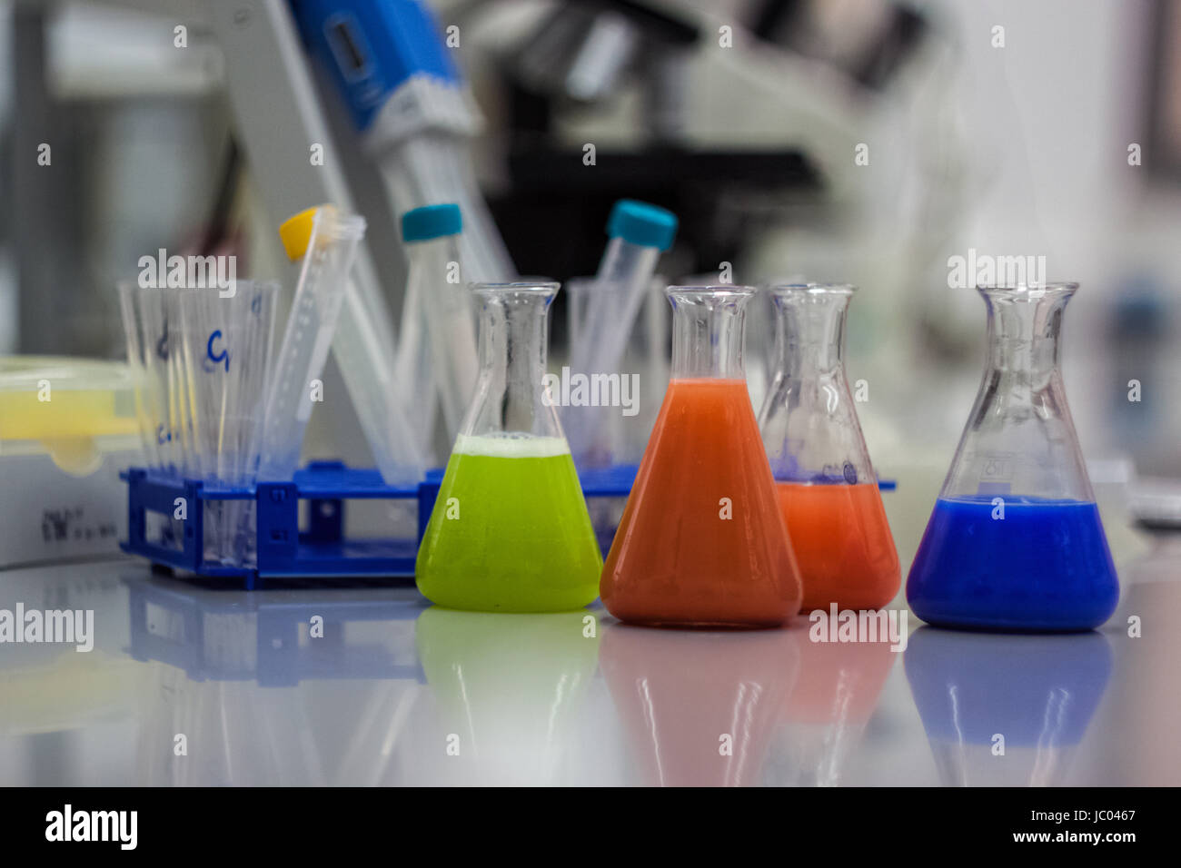 Laboratoire de biotechnologie de l'équipement pour la recherche. Bouteilles, flacons et les pipettes avec orange de couleur vert et bleu des liquides et des échantillons d'ADN Banque D'Images