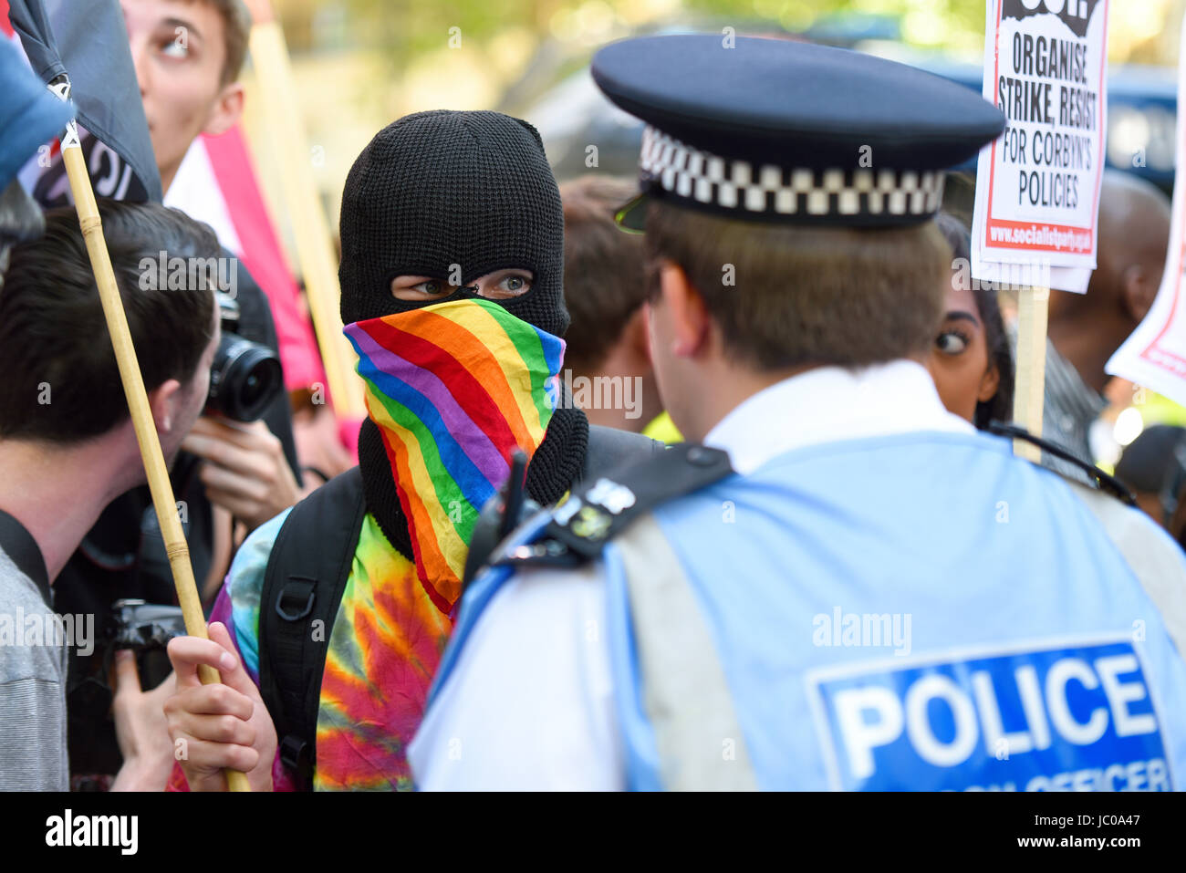 Les manifestants contre l'alliance Tory DUP se sont rassemblés sur la place du Parlement et ont marché sur Downing Street. Londres. Manifestant masqué et police Banque D'Images