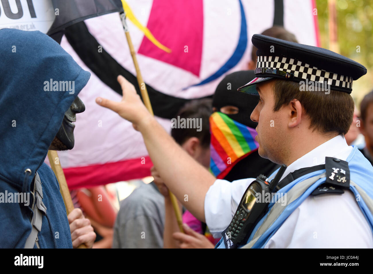 Les manifestants contre l'alliance Tory DUP se sont rassemblés sur la place du Parlement et ont marché sur Downing Street. Londres. Manifestant masqué et police Banque D'Images