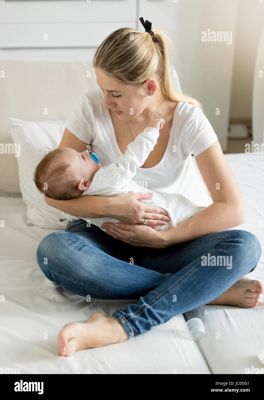 Young Cheerful Mere Assis Sur Le Lit Avec Elle 3 Mois Bebe Garcon Photo Stock Alamy