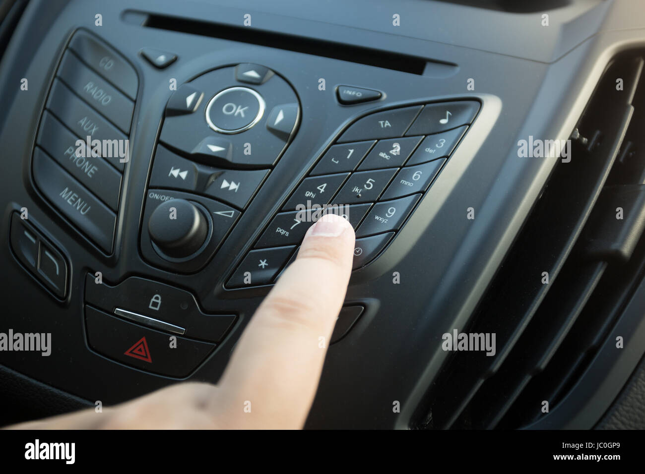 Photo Gros plan femme d'appui bouton sur le tableau de bord de voiture Banque D'Images