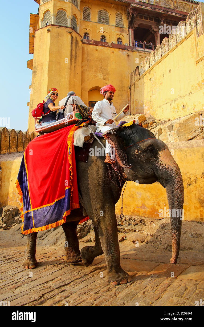 Décorées avec des touristes de l'éléphant passe le chemin pavé à Fort Amber près de Jaipur, Rajasthan, Inde. Des promenades en éléphant sont populaires'attirer Banque D'Images