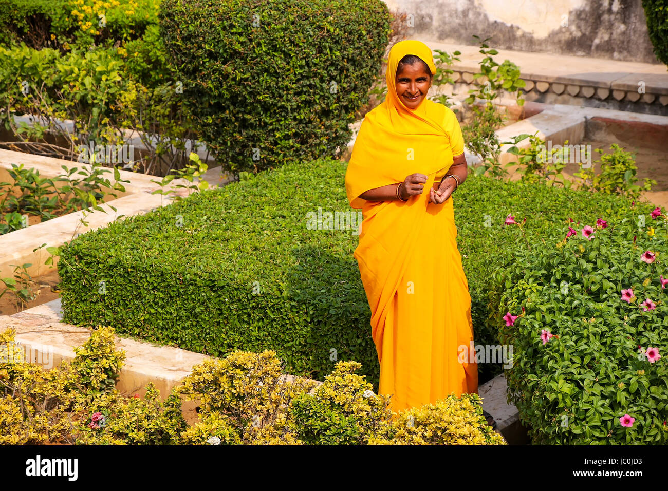 Femme marche à travers le jardin en troisième cour du Fort Amber, Rajasthan, Inde. Fort Amber est la principale attraction touristique dans la région de Jaipur. Banque D'Images