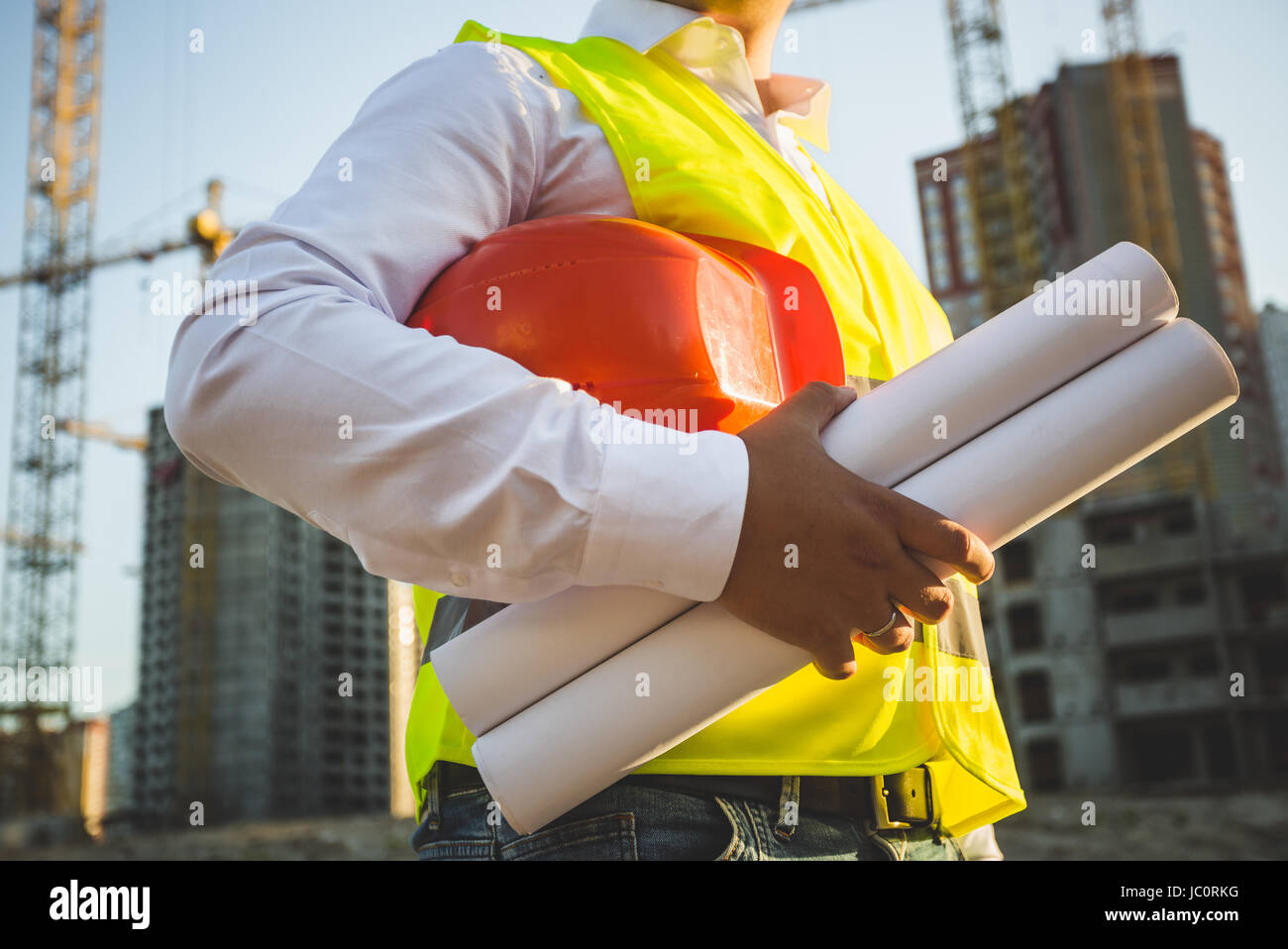 Photo gros plan de l'homme en chemise et veste tenue casque de protection  et des plans de chantier Photo Stock - Alamy