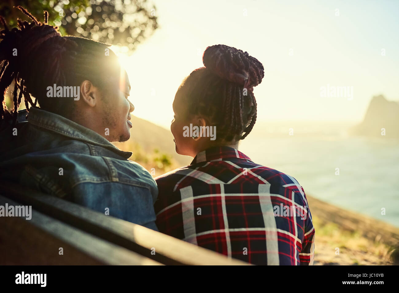 Couple d'origine africaine assise sur un banc public viewpoint Banque D'Images