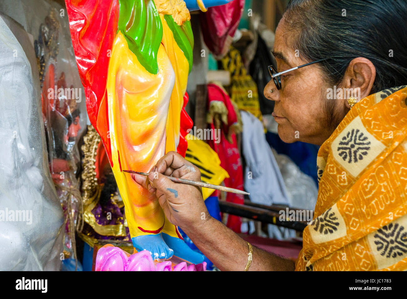 Une femme est la peinture à une statue dans le quartier kumartuli Banque D'Images