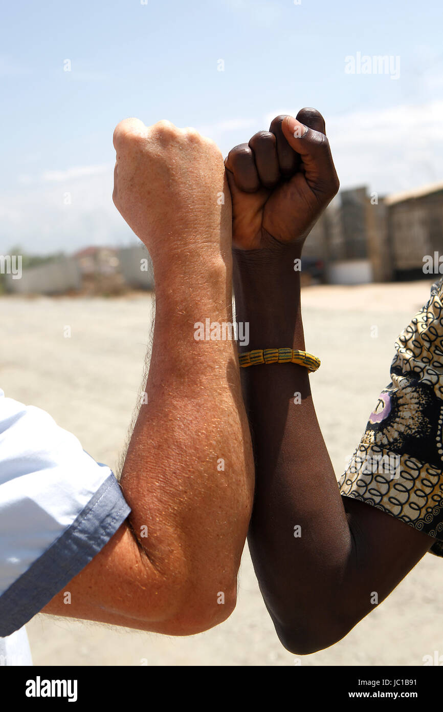Poignée de main entre un Blanc et un Africain sur fond gris Banque D'Images