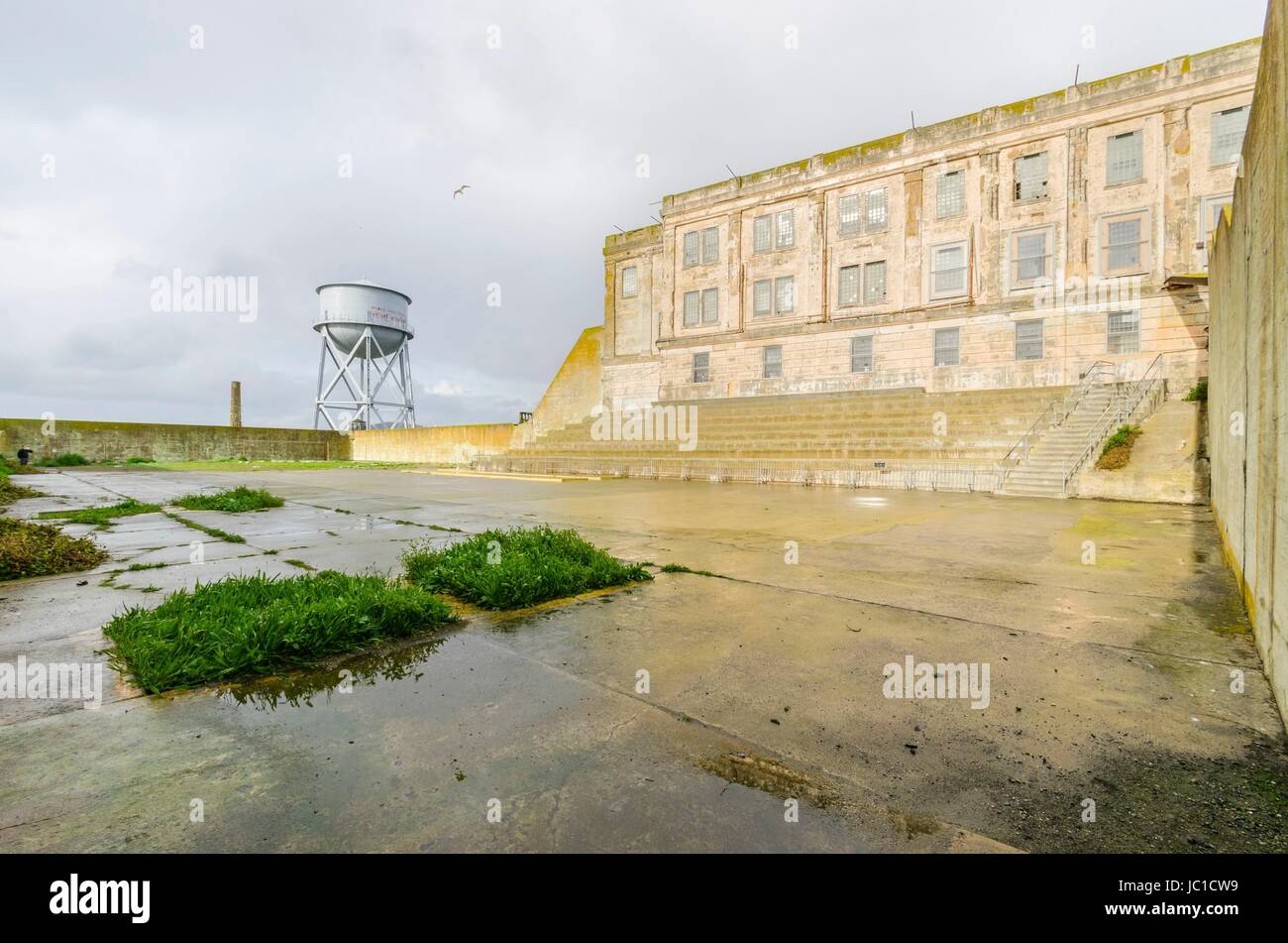 La cour de récréation sur l'île pénitencier d'Alcatraz, maintenant un musée, à San Francisco, Californie, USA. Une vue de la cour d'exercice, l'cellhouse et l'ancien château d'eau. Banque D'Images