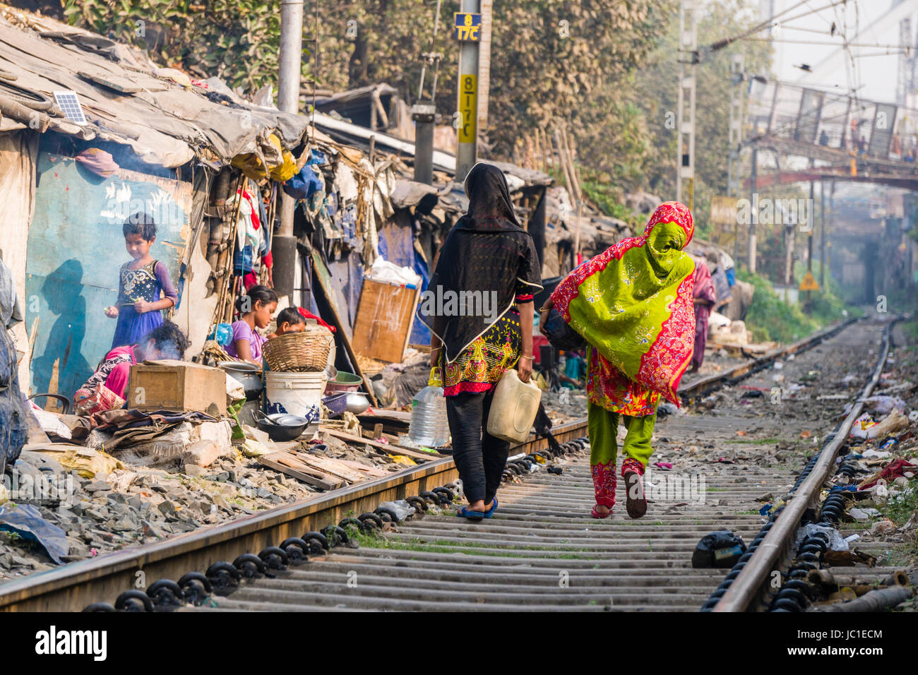 Les habitations et des huttes en Chine bazar bidonville sont situés juste à côté de la voie ferrée, les gens marchent sur les pistes Banque D'Images