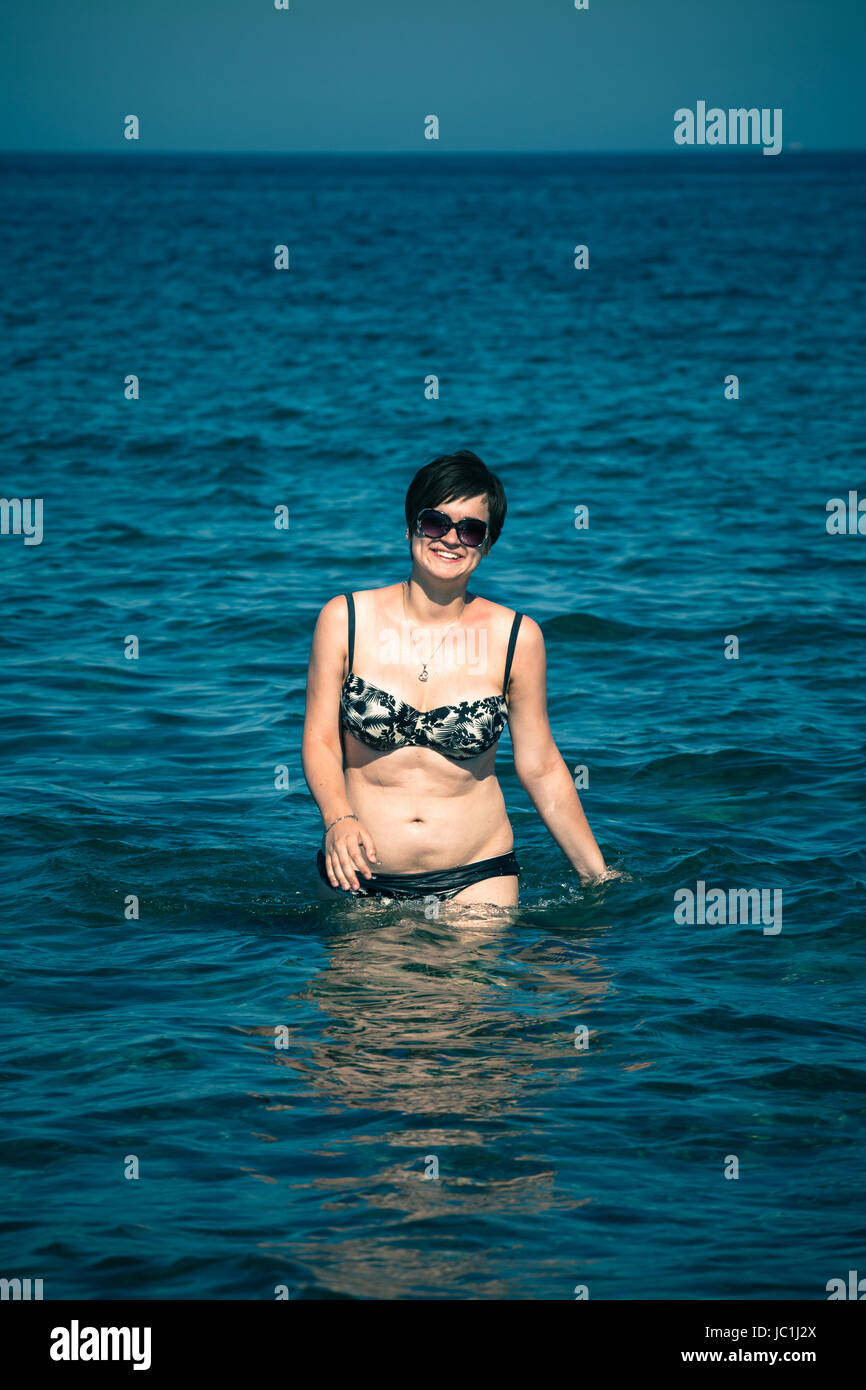 Jeune femme heureuse de marcher dans la mer. Banque D'Images