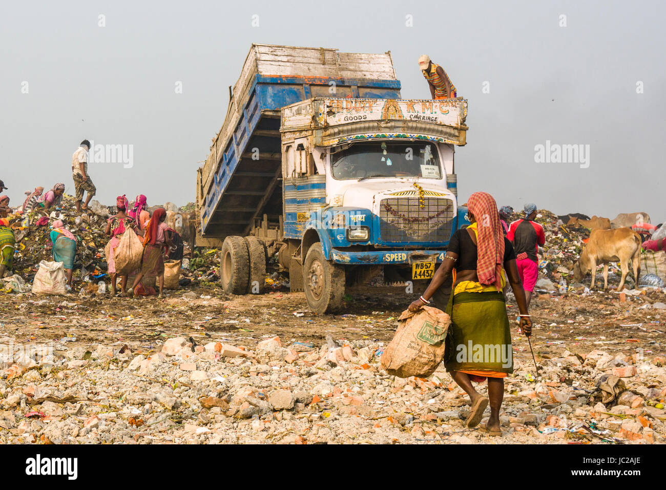Un camion chargé de déchets est le déchargement sur haut de dusty dhapa dépotoir, les travailleurs sont la collecte des matériaux recyclables Banque D'Images