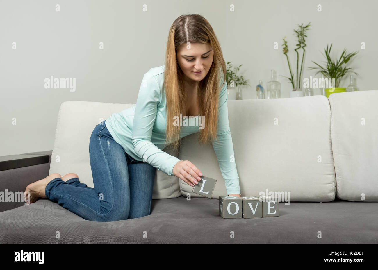 Jeune femme rendant le mot 'Amour' des briques avec des lettres Banque D'Images