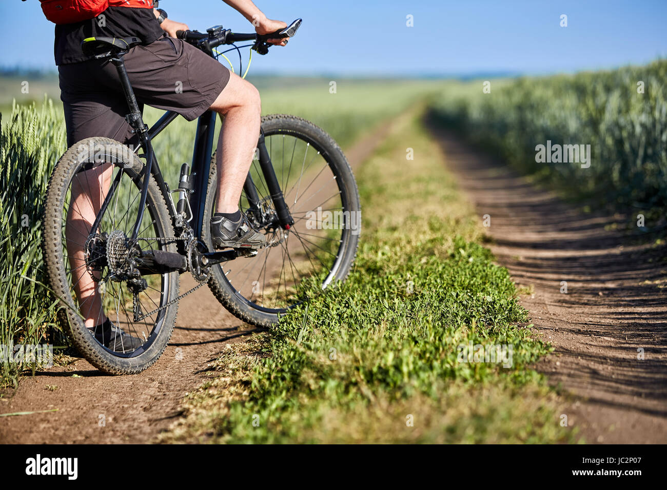 Close-up de cycliste homme jambes avec vtt sur la piste de champ dans la  campagne. Détail de la location et sportsman, sportif chaussures et blac  Photo Stock - Alamy