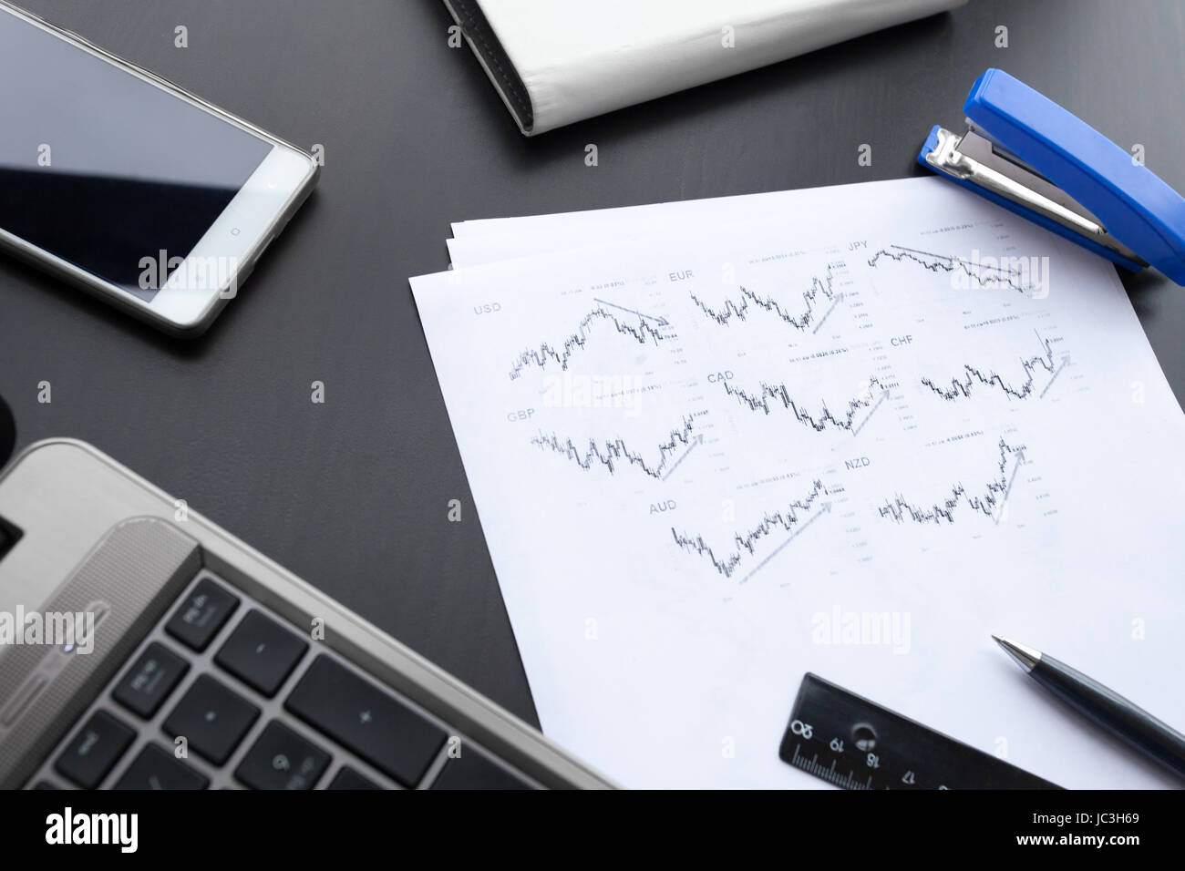 Papier graphique, ordinateur portable, téléphone et un stylo sur la table office Banque D'Images