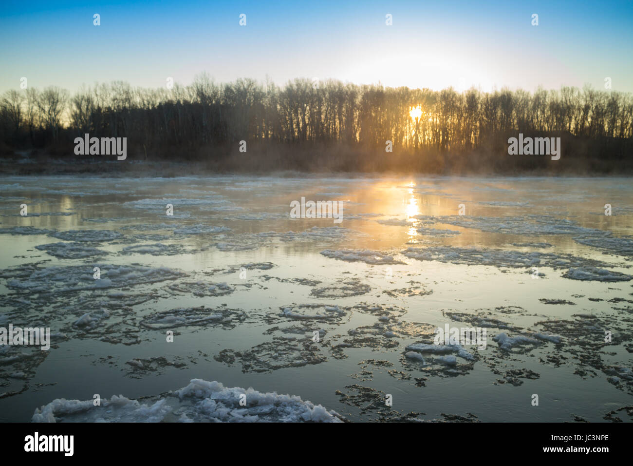Lever du soleil sur les rives de la rivière de brouillard et gel Banque D'Images
