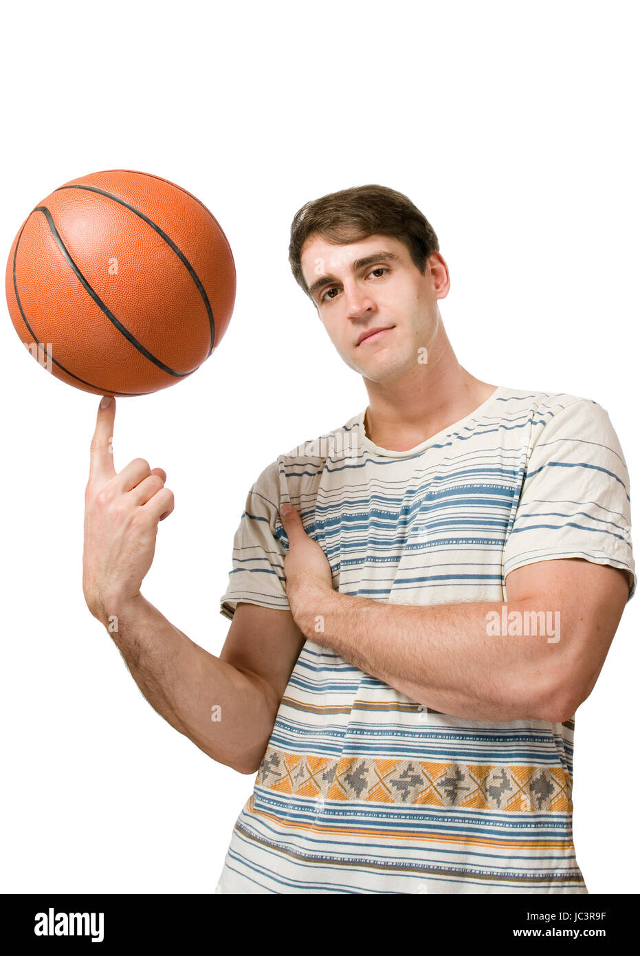 Oberkörper-Ansicht eines jungen Mannes im gestreiften T-Shirt weissen vor der Hintergrund und jonglierend Basket-ball cool dans Die Kamera blickend Banque D'Images