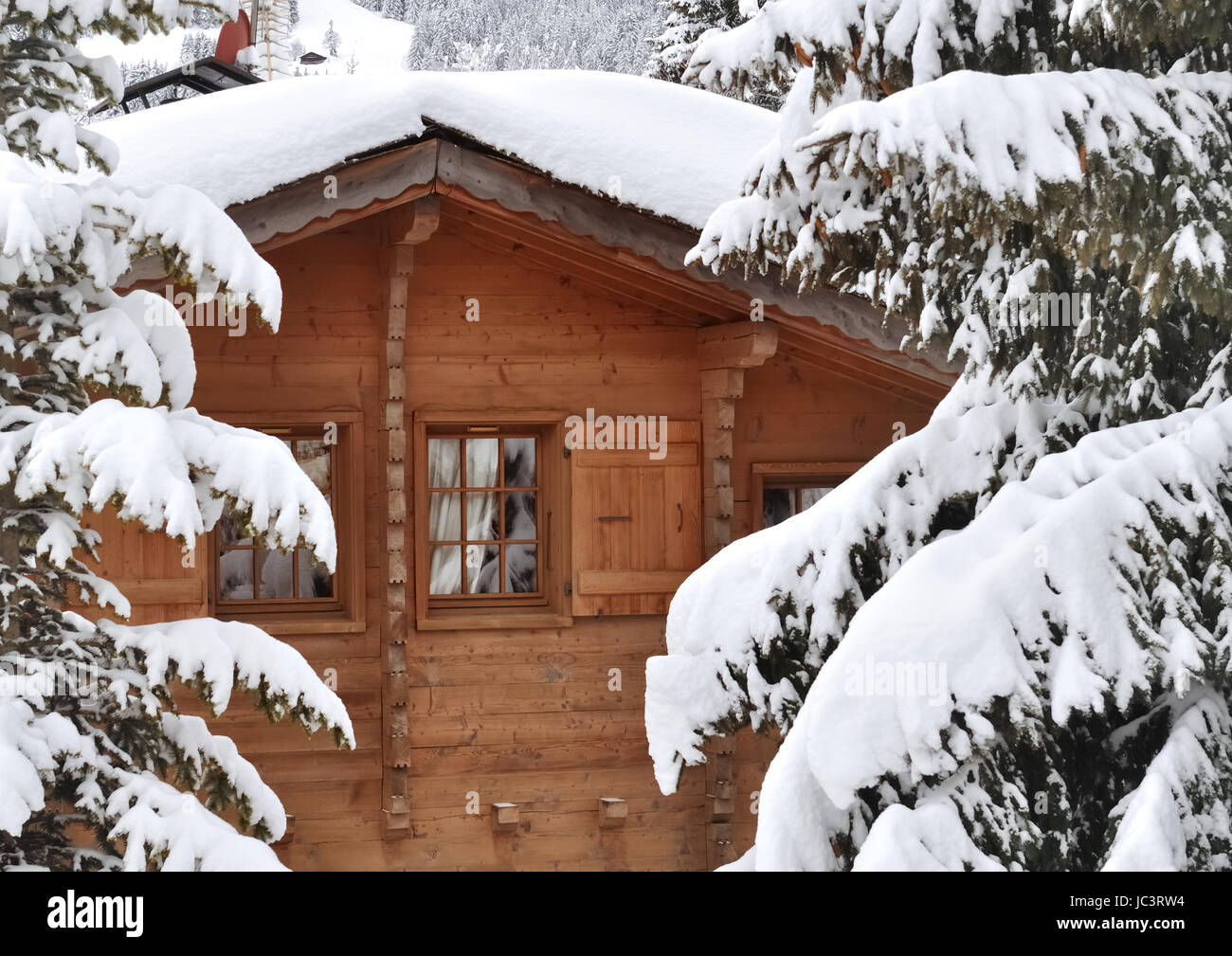 Fenêtre sur un cottage en bois façade dans la première neige Banque D'Images