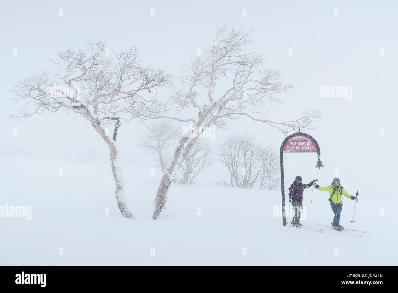 Deux skieurs ne sonne une cloche pour satisfaire les dieux de montagne dans station de ski Niseko United sur Hokkaido, Japon. On croit dans le Shinto que tous les objets naturels sont des dieux. Chaque fois que vous payez l'égard ils va vous protéger. Banque D'Images