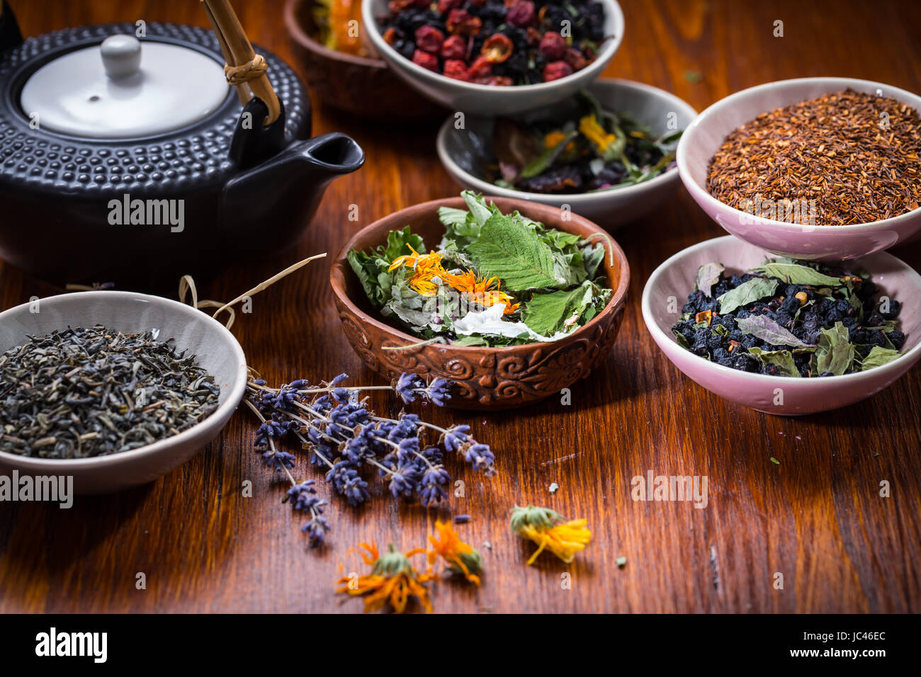 Assortiment de fruits et de plantes dans des bols de thé Banque D'Images