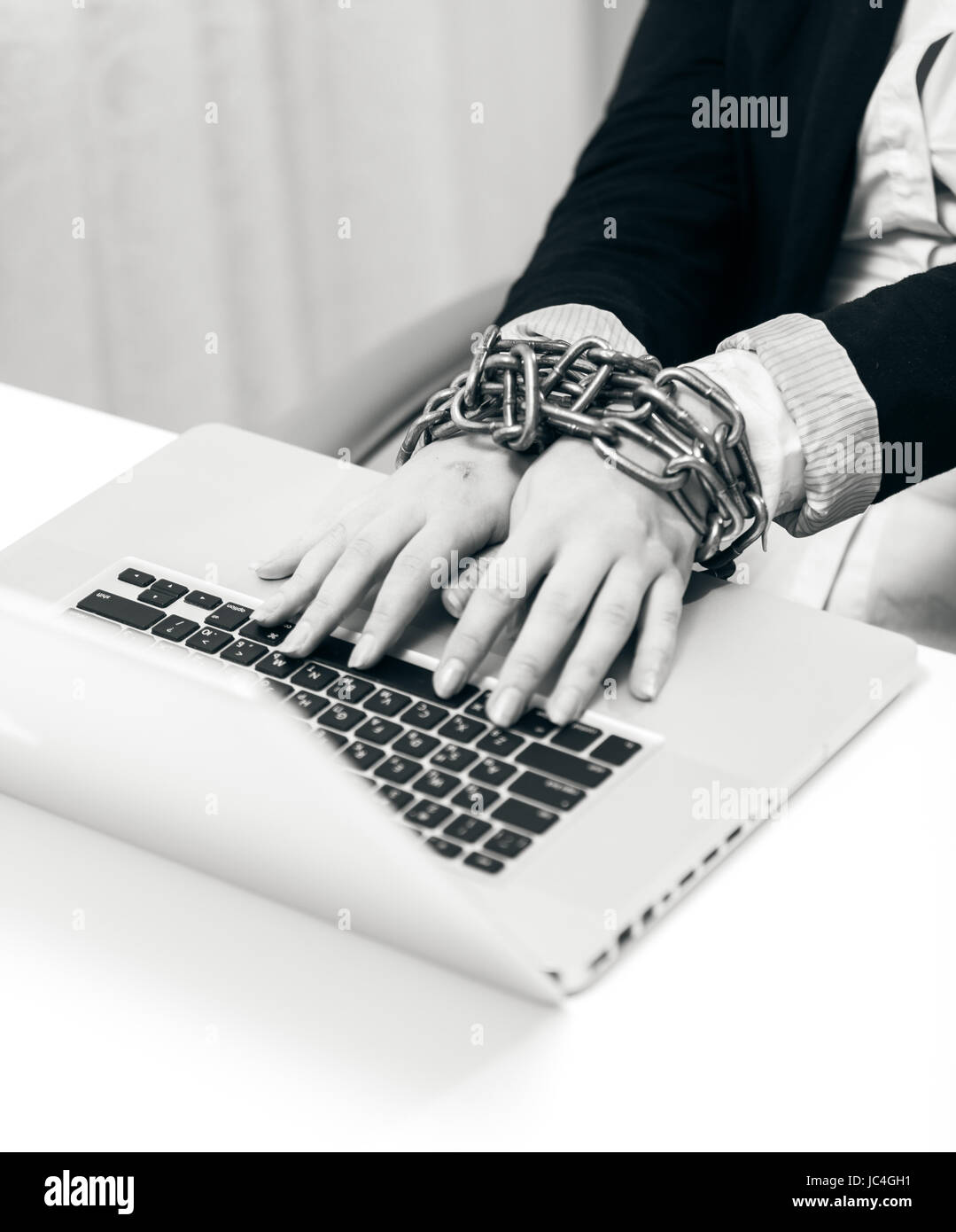 Gros plan noir et blanc la photo d'une femme à l'ordinateur portable verrouillé par chaîne Banque D'Images