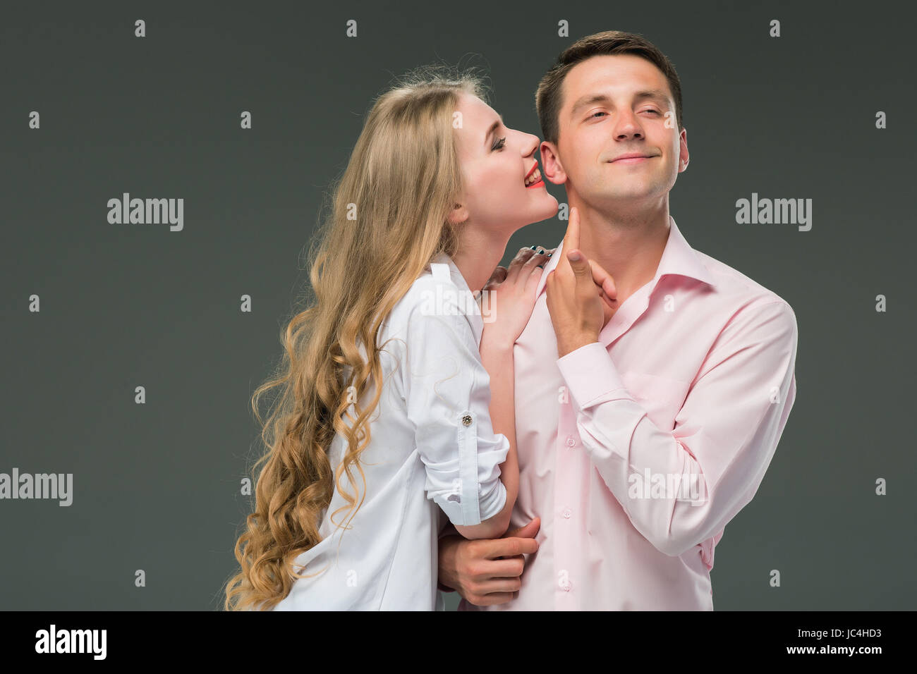 Portrait d'un jeune couple debout contre l'arrière-plan gris Banque D'Images