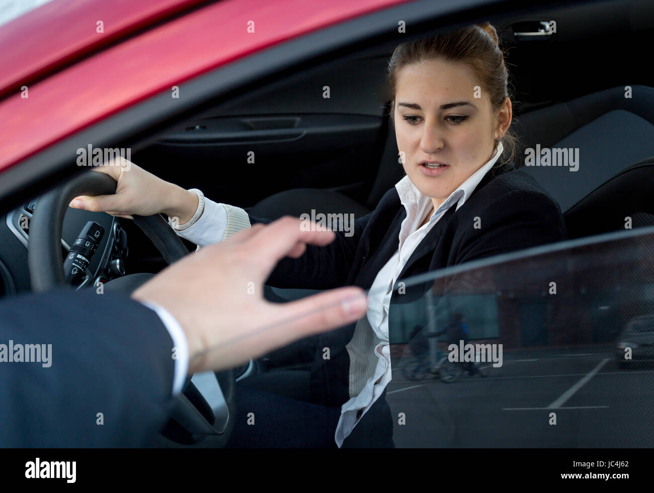 Jeune femme peur de cambrioleur essayant de pénétrer dans la voiture Banque D'Images