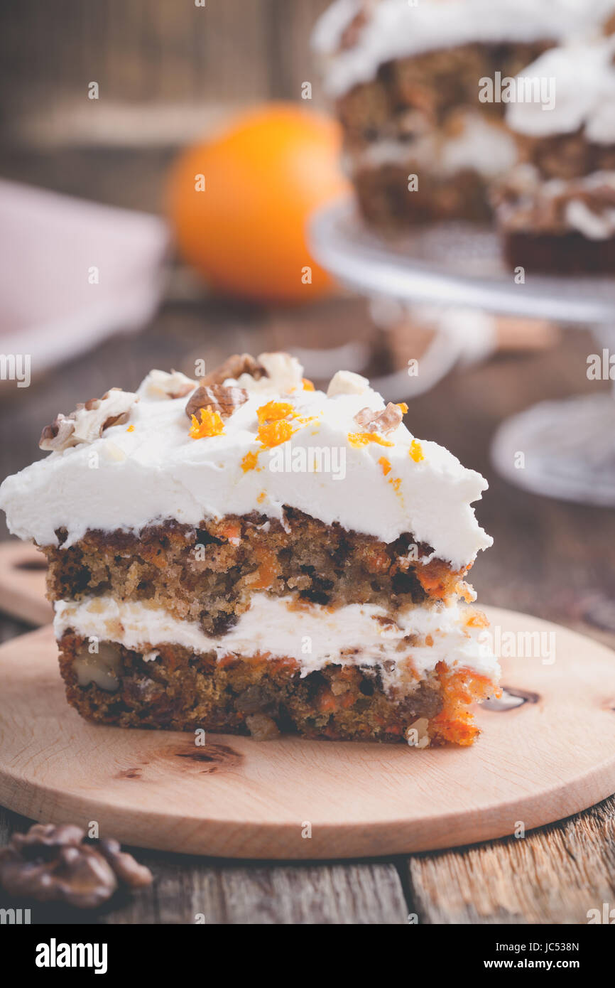 Gâteau aux carottes à la cannelle, noix et orange de fromage fondu sur table en bois rustique Banque D'Images