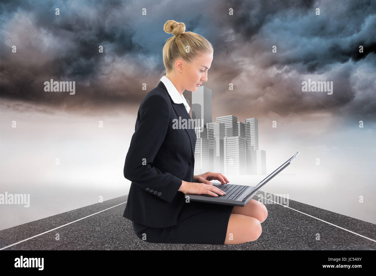 Image composite de blond businesswoman using laptop Banque D'Images