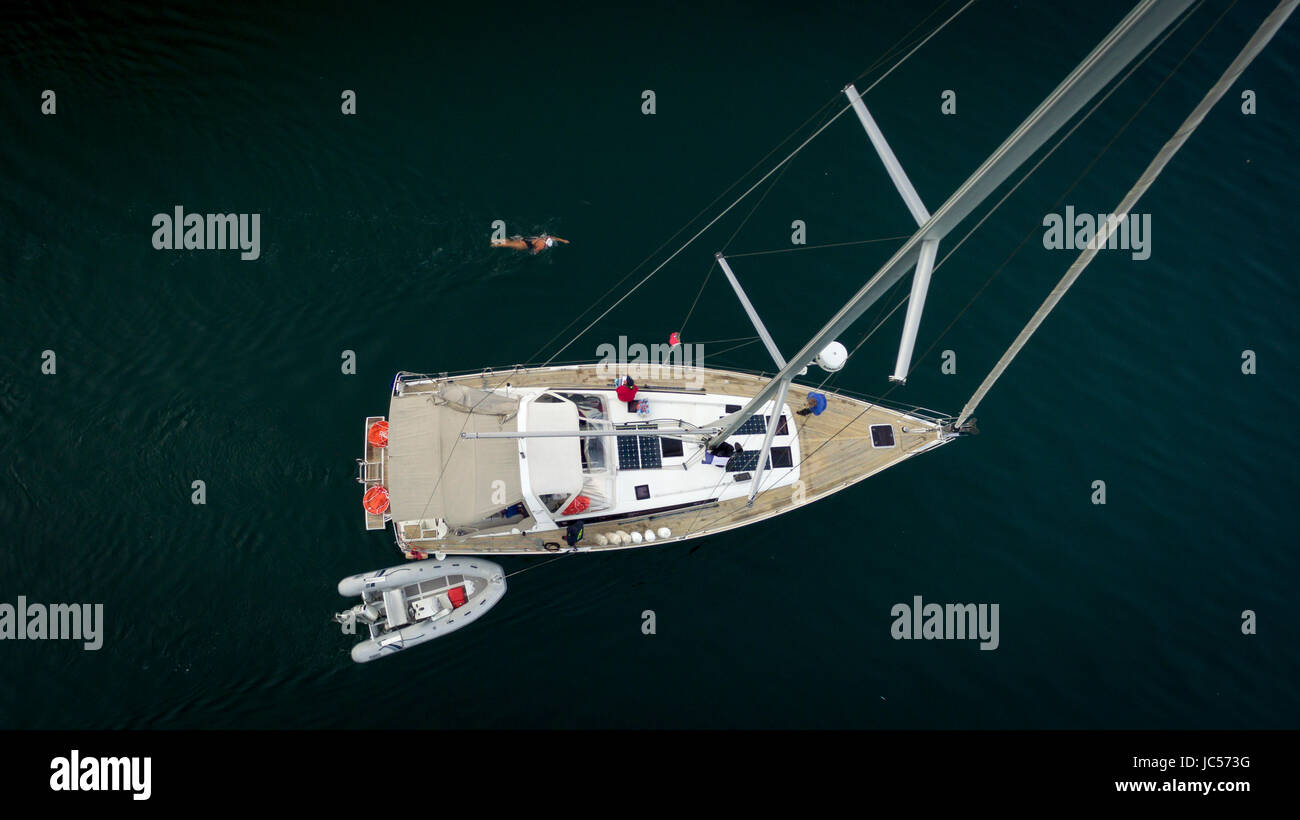 Vue aérienne d'un bateau à voile sur le lac de Genève, d'un zodiac attaché à la voile et d'un nageur solitaire en haut de l'image, dans le Canton de Vaud, Suisse Banque D'Images