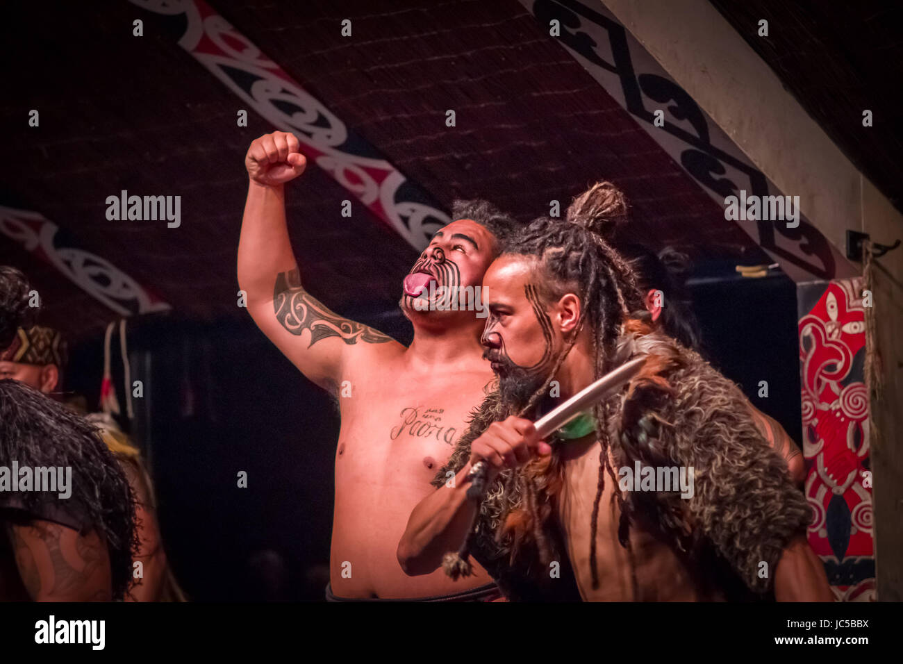 L'ÎLE DU NORD, Nouvelle-zélande - 17 MAI 2017 : Tamaki Maori est un hommes sticking out tongue avec main tatouée traditionnellement face et en vêtements traditionnels maoris à Banque D'Images