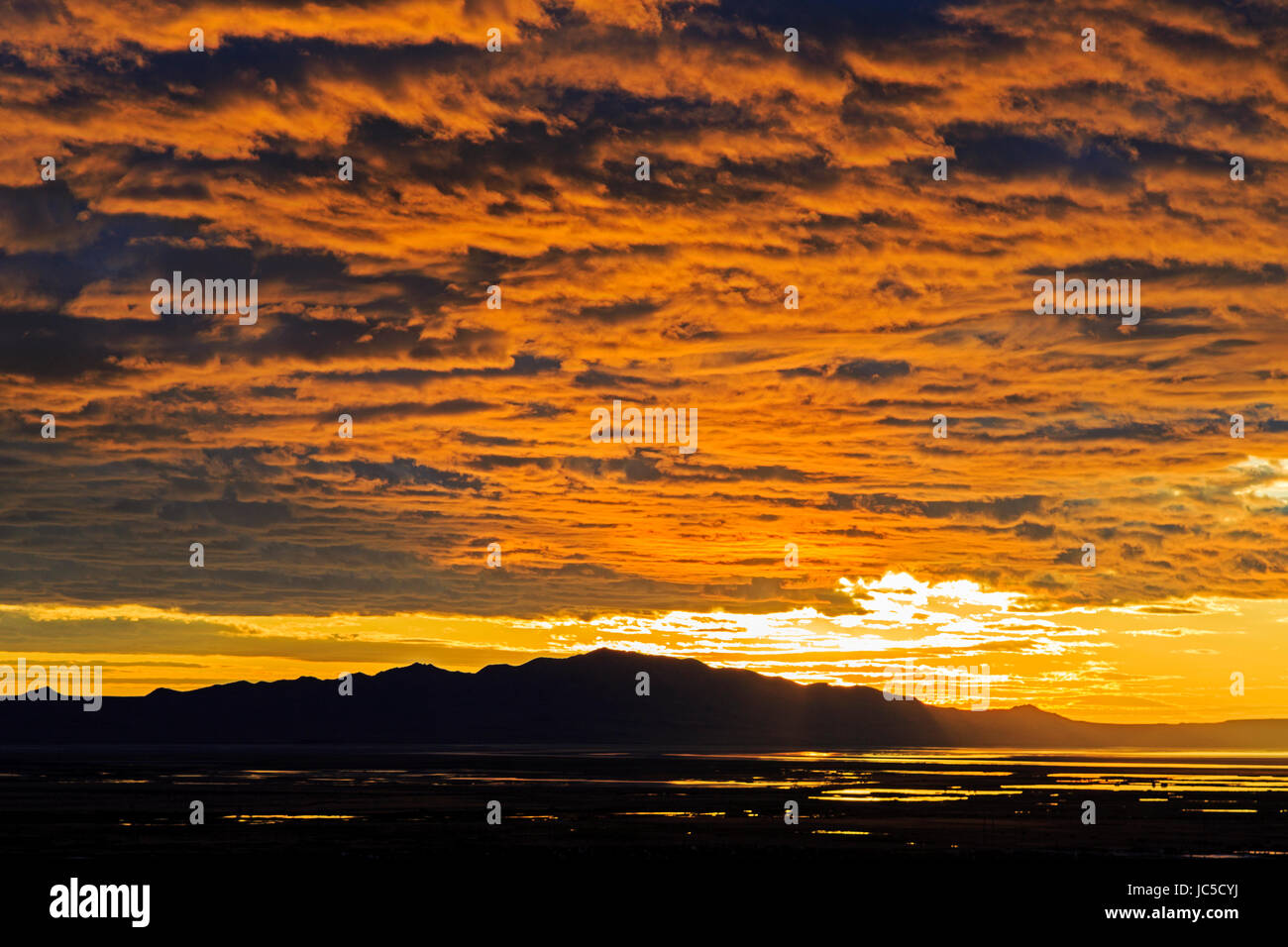 Le soleil s'allume en bas des nuages qu'elle commence à se coucher sur l'île de l'Antilope. Antelope Island est la plus grande île dans le Grand Lac Salé. Banque D'Images