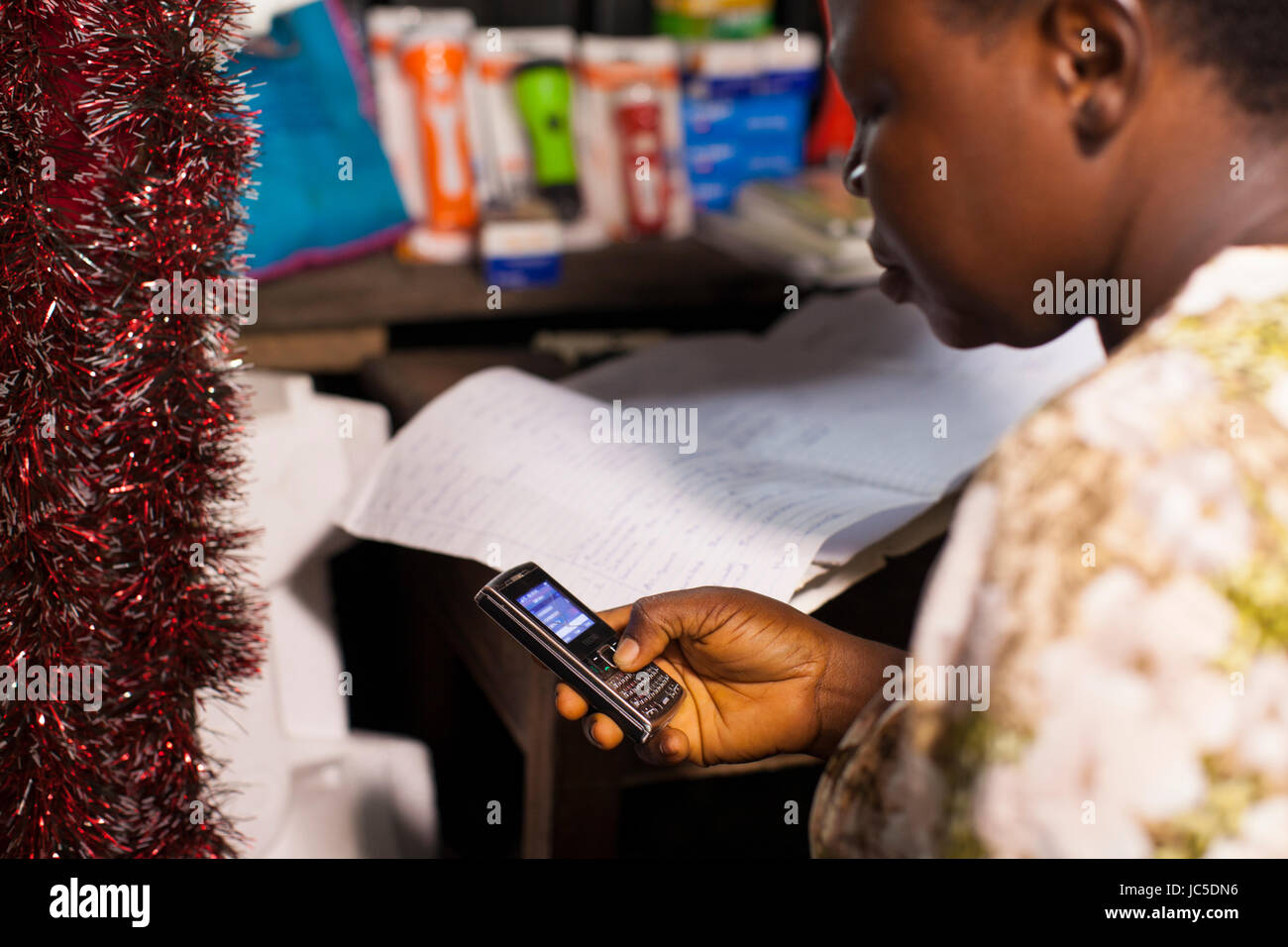 Une femme à l'aide de son téléphone portable à l'œuvre, le Nigeria, l'Afrique Banque D'Images Une femme à l'aide de son téléphone portable à l'œuvre, le Nigeria, l'Afrique Banque D'Images